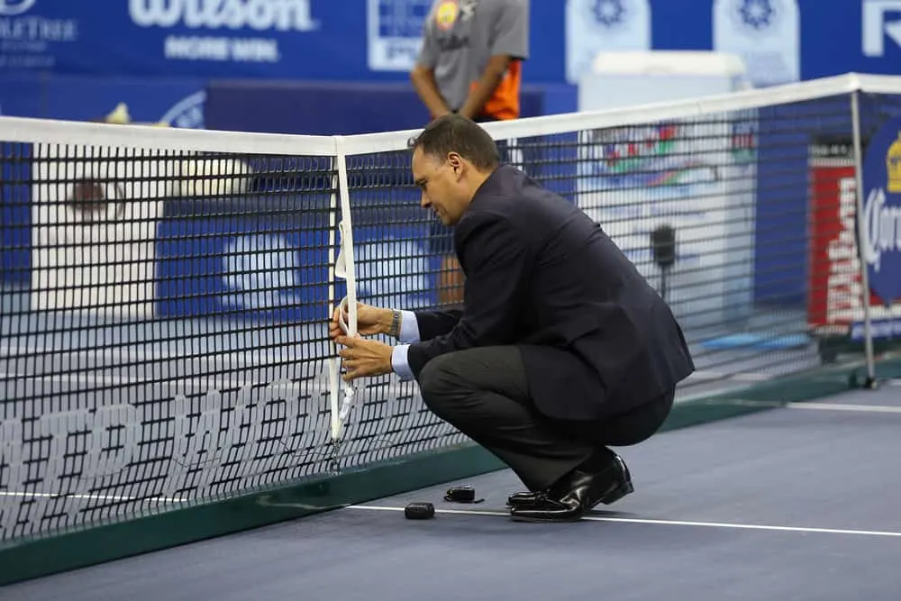 Umpire Mohamed Lahyani of Sweden measures the net height tennis