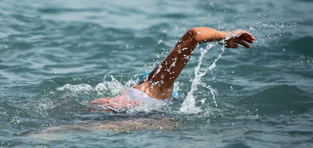 Man swimmer swimming crawl in blue sea,training for triathlon