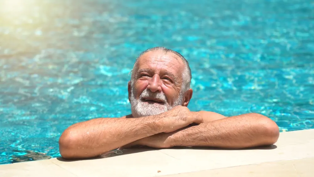 Senior man swimming in an outdoor swimming pool