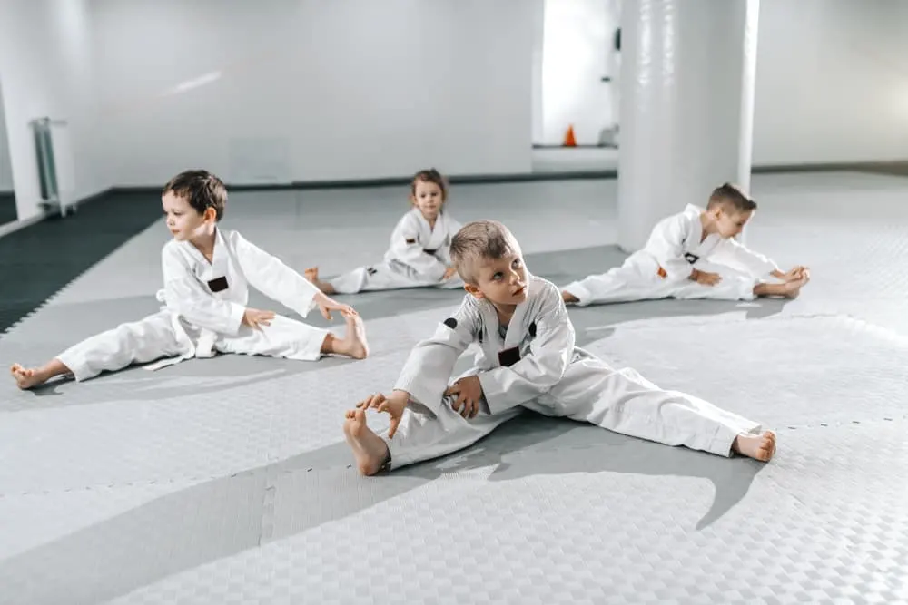 children stretching and warming up before their taekwondo training